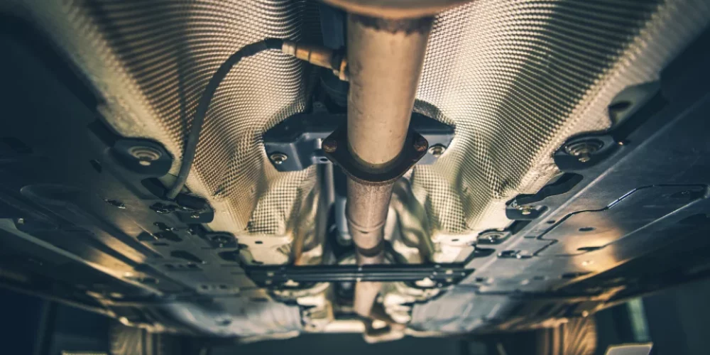 Zdjęcie przedstawia układ wydechowy zamontowany na samochodzie